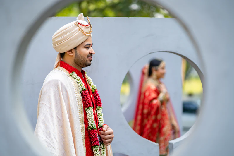 A man tying a white turban in front of a mirror